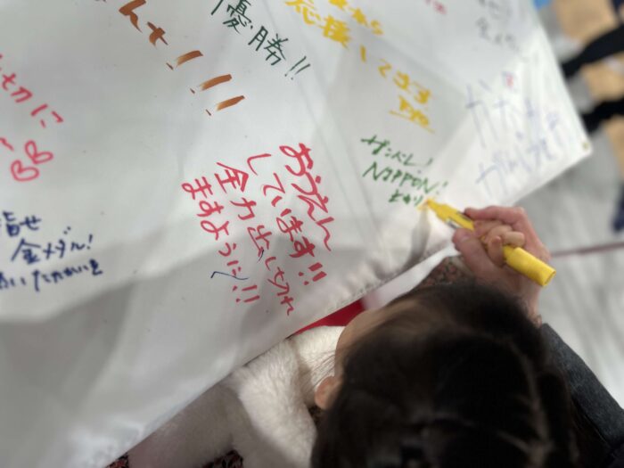 三菱電機のブース。男子U23日本代表に贈る応援フラッグにメッセージを書きました